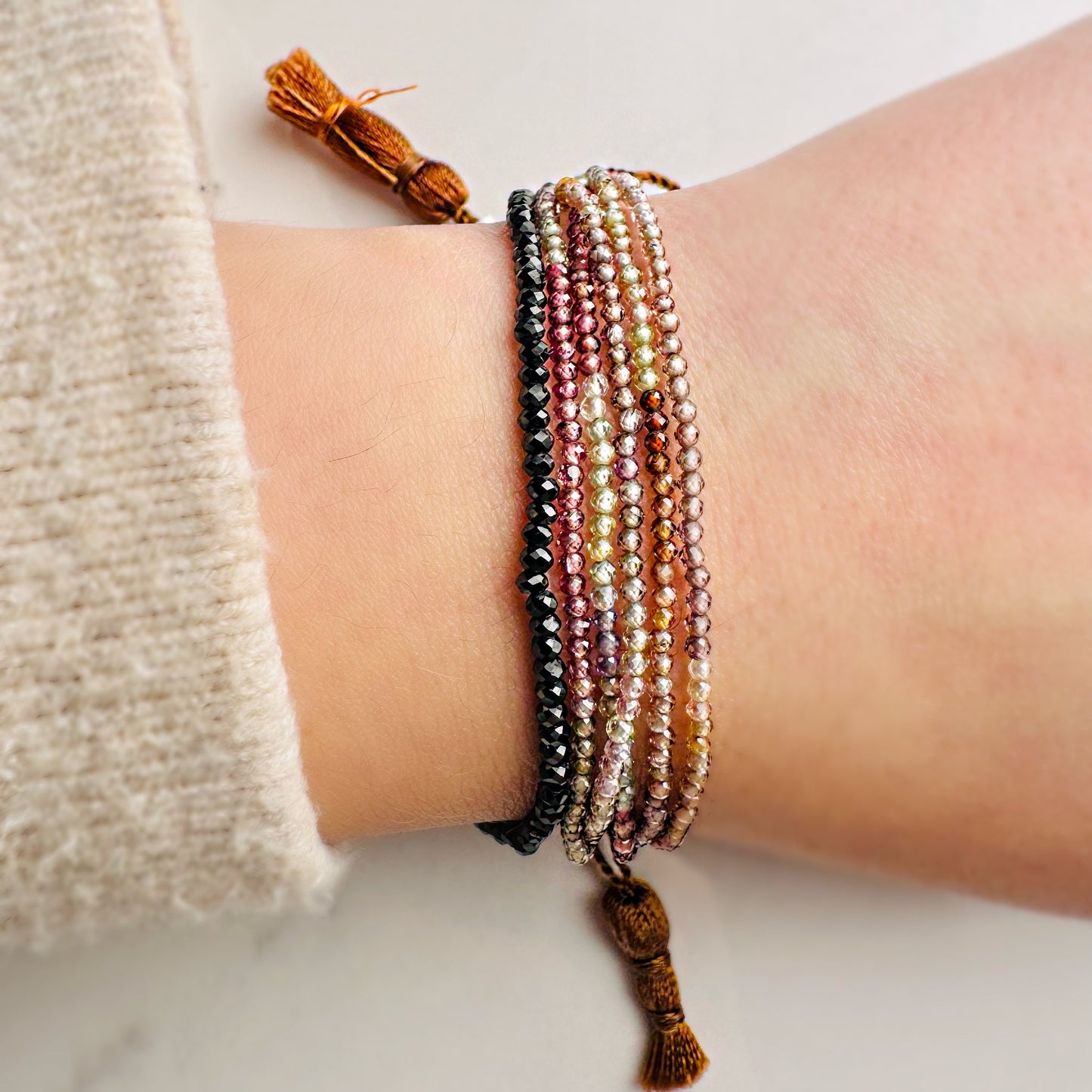 Beaded bracelets on a wrist with a neutral background